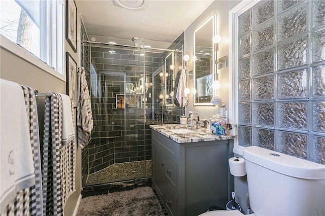 bathroom with walk in shower, vanity, and toilet