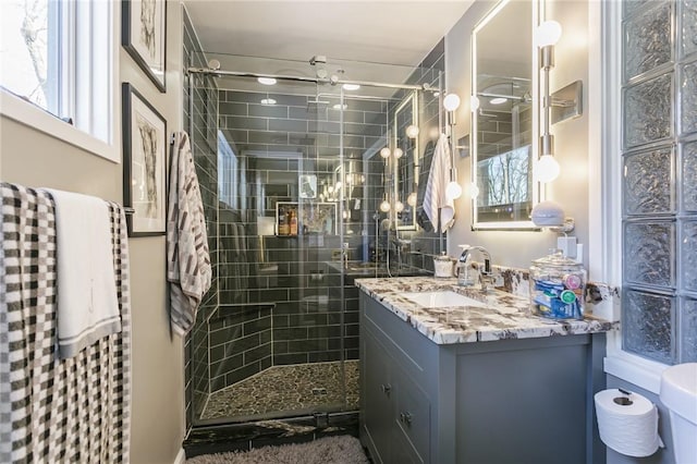 bathroom featuring vanity, toilet, and tiled shower