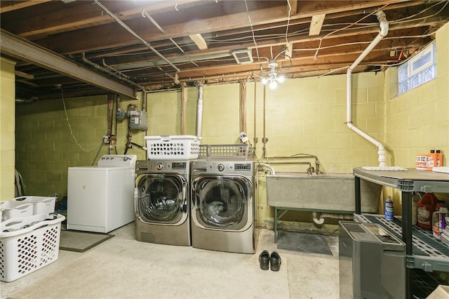 laundry area with independent washer and dryer and sink