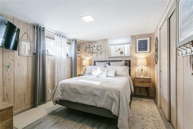 bedroom featuring wooden walls and a textured ceiling