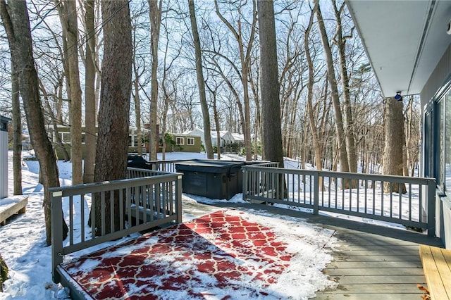 snow covered deck featuring a hot tub