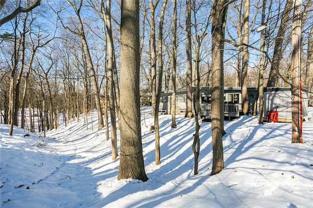 snowy yard featuring a wooden deck