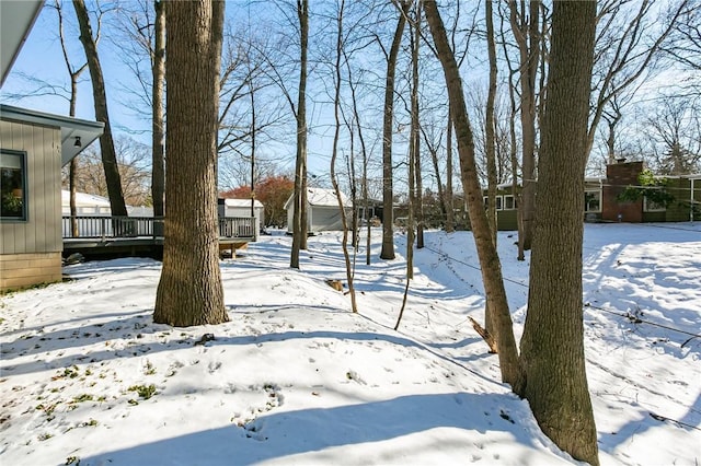 yard layered in snow featuring a deck