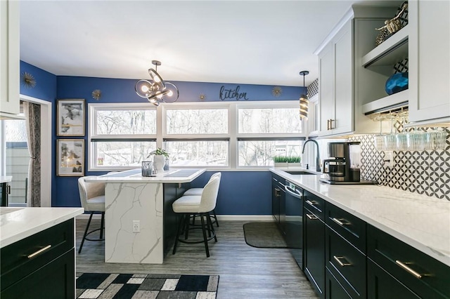 kitchen featuring white cabinetry, sink, a breakfast bar, and pendant lighting