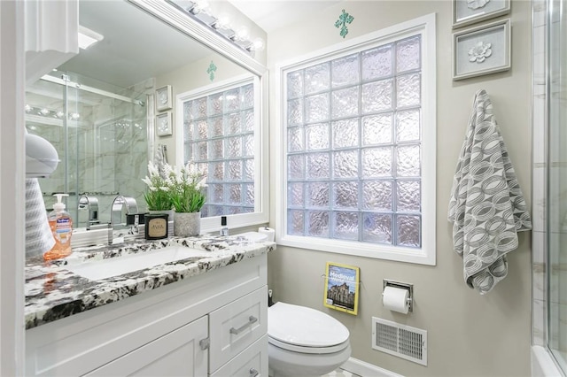 bathroom featuring an enclosed shower, vanity, and toilet