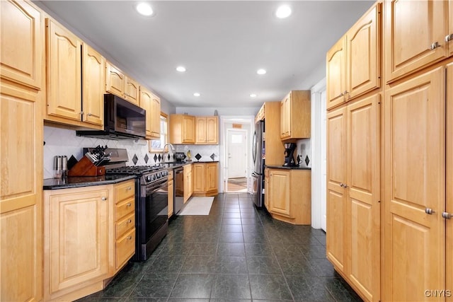 kitchen featuring sink, light brown cabinets, appliances with stainless steel finishes, dark tile patterned flooring, and backsplash