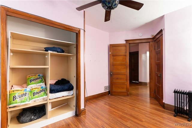 bedroom featuring ceiling fan, a closet, and light hardwood / wood-style flooring