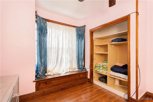 bedroom featuring ceiling fan, hardwood / wood-style floors, and multiple windows