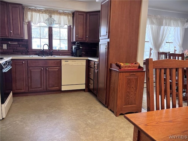 kitchen featuring tasteful backsplash, dishwasher, sink, and range