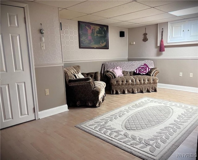 living area with hardwood / wood-style floors and a drop ceiling