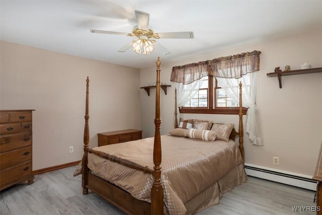 bedroom featuring ceiling fan, a baseboard heating unit, and light hardwood / wood-style floors