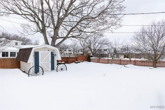 yard covered in snow featuring a storage shed