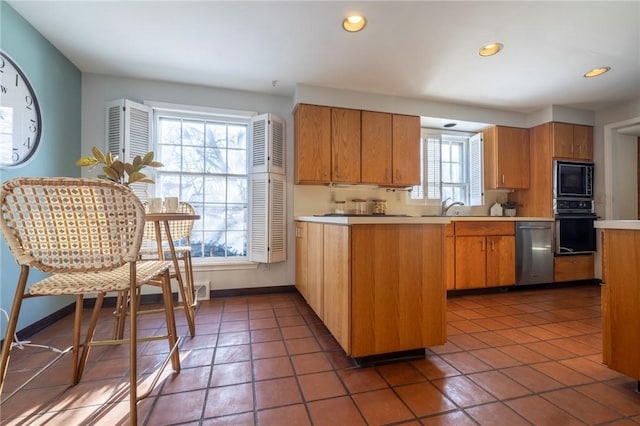 kitchen featuring kitchen peninsula, sink, dark tile patterned flooring, and black appliances