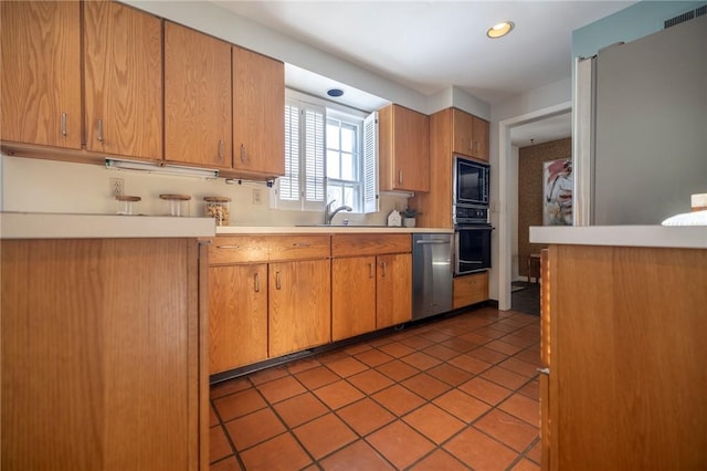 kitchen featuring sink, light tile patterned floors, and black appliances