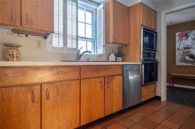 kitchen featuring dark tile patterned flooring, sink, and black appliances