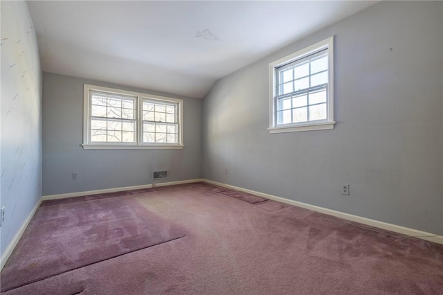 empty room with vaulted ceiling and carpet floors