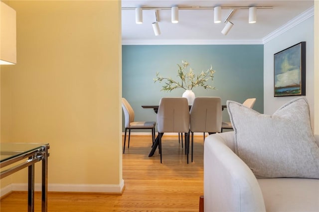 dining area featuring ornamental molding and light hardwood / wood-style flooring