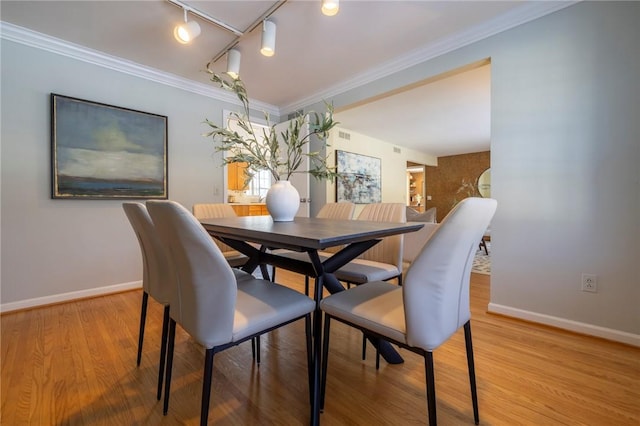 dining area with hardwood / wood-style flooring and ornamental molding