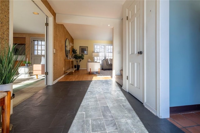 hallway featuring a healthy amount of sunlight and vaulted ceiling