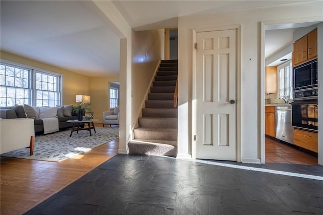 staircase with hardwood / wood-style floors and sink