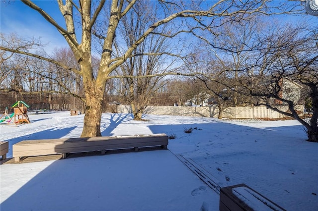 yard layered in snow featuring a playground