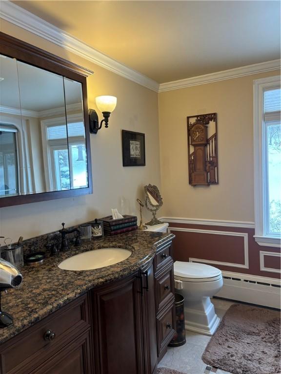 bathroom featuring vanity, a baseboard heating unit, ornamental molding, and toilet