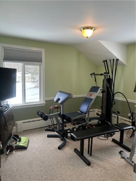 workout room with vaulted ceiling, a baseboard radiator, and carpet