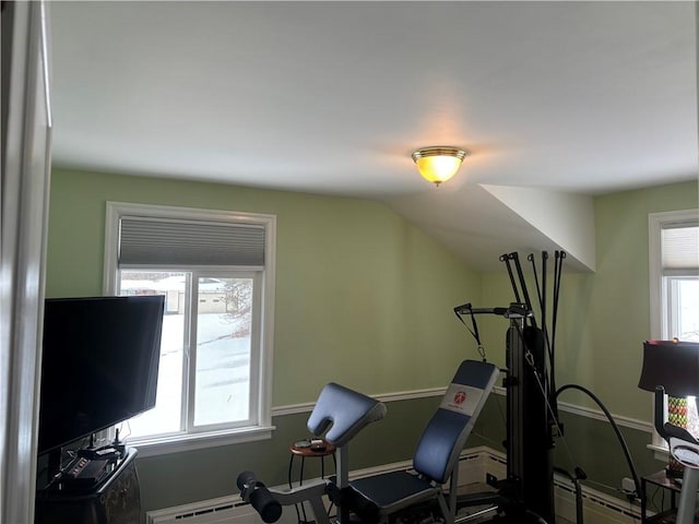 exercise room featuring lofted ceiling and baseboard heating