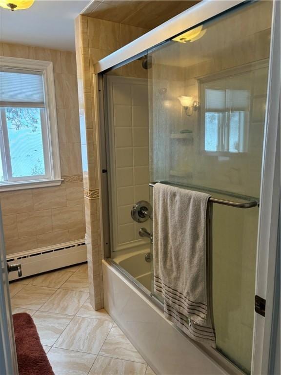 bathroom featuring a baseboard radiator, combined bath / shower with glass door, and tile walls