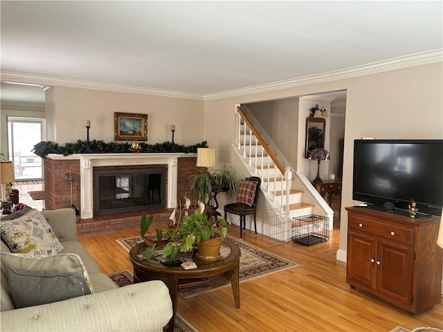 living room featuring crown molding, a fireplace, and light hardwood / wood-style floors