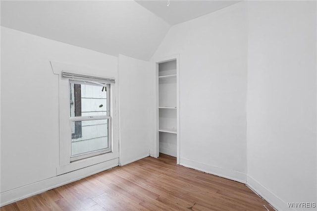 unfurnished bedroom with a closet, lofted ceiling, and light hardwood / wood-style flooring