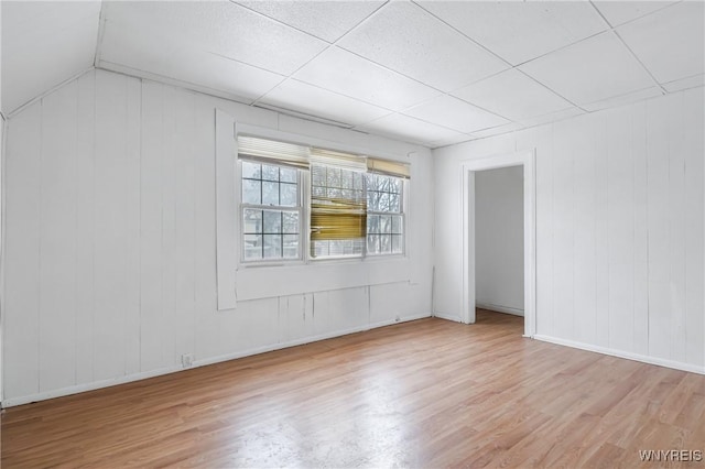 spare room with lofted ceiling and light hardwood / wood-style flooring