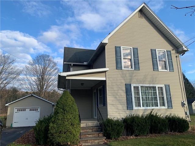 view of front facade featuring a garage and an outbuilding