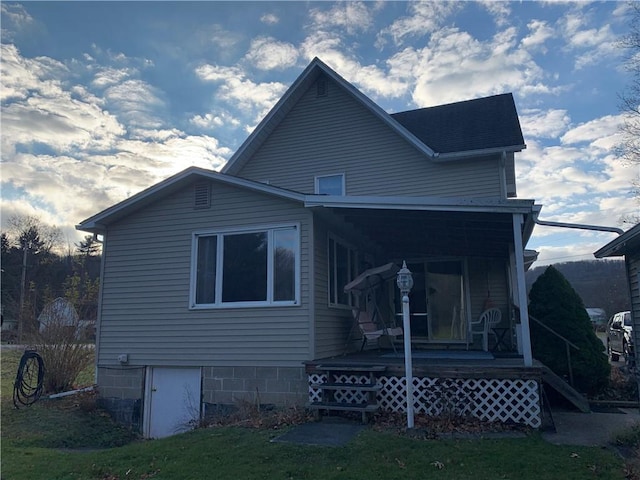 rear view of house with a yard and covered porch