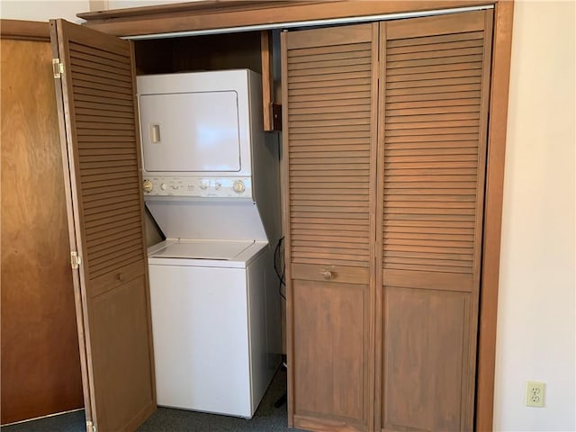 clothes washing area featuring stacked washer / dryer