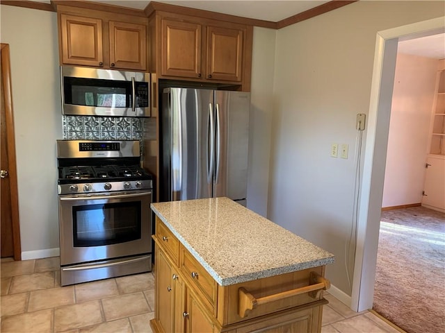 kitchen featuring light stone counters, light colored carpet, stainless steel appliances, and a center island