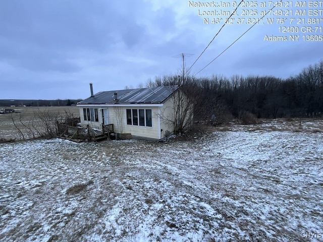 snow covered property with solar panels