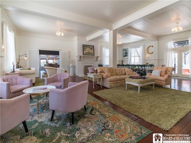 living room with beamed ceiling, hardwood / wood-style floors, a notable chandelier, and french doors