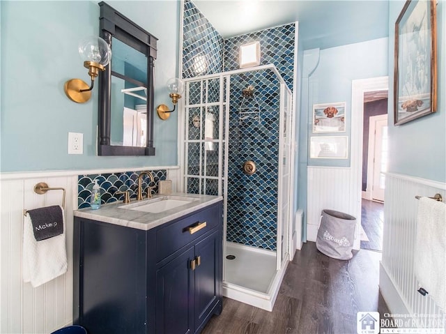 bathroom featuring vanity, wood-type flooring, and a tile shower