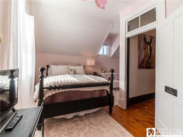 bedroom featuring hardwood / wood-style flooring and vaulted ceiling