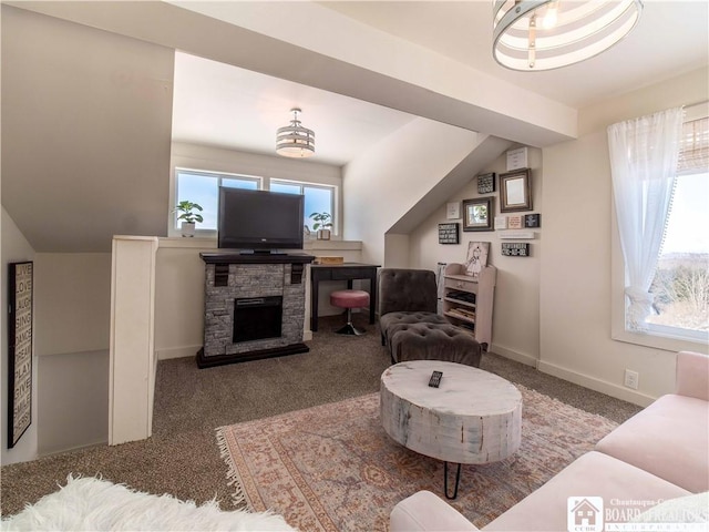 living room featuring a healthy amount of sunlight, a stone fireplace, and carpet floors