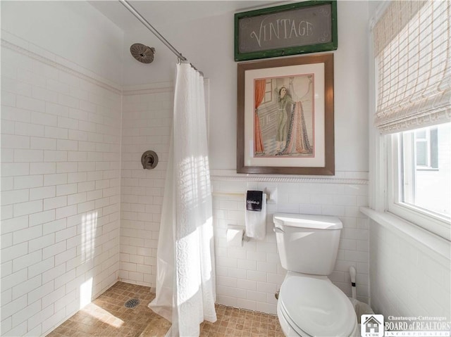 bathroom with tile walls, curtained shower, and toilet