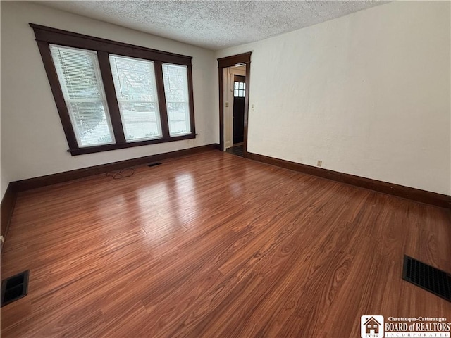 empty room featuring hardwood / wood-style flooring and a textured ceiling