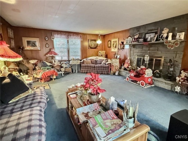 living room featuring a stone fireplace, carpet floors, and wood walls