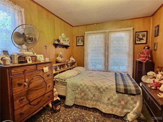 bedroom featuring wooden walls and ornamental molding