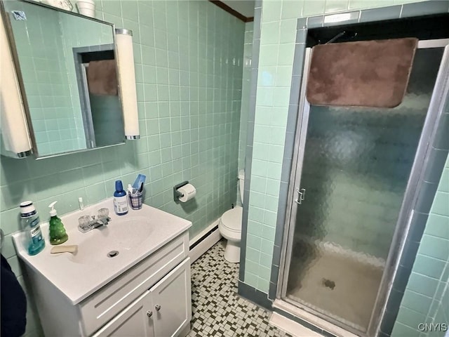 bathroom with tile walls, a baseboard heating unit, vanity, and a shower with shower door