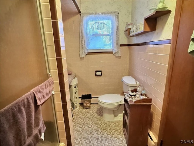 bathroom with a baseboard heating unit, tile walls, and toilet