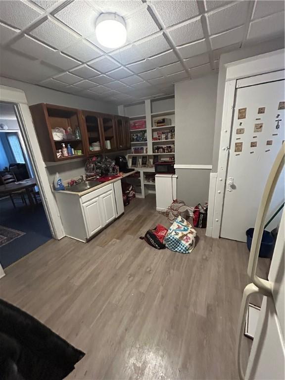 kitchen with a drop ceiling and wood-type flooring