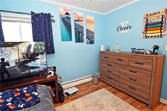 bedroom with a baseboard heating unit, hardwood / wood-style flooring, and ornamental molding