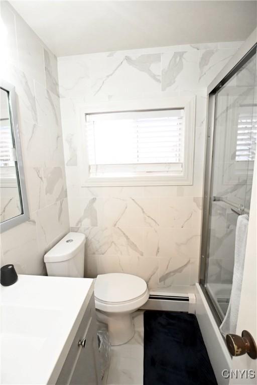 bathroom featuring tile walls, vanity, a baseboard radiator, toilet, and walk in shower